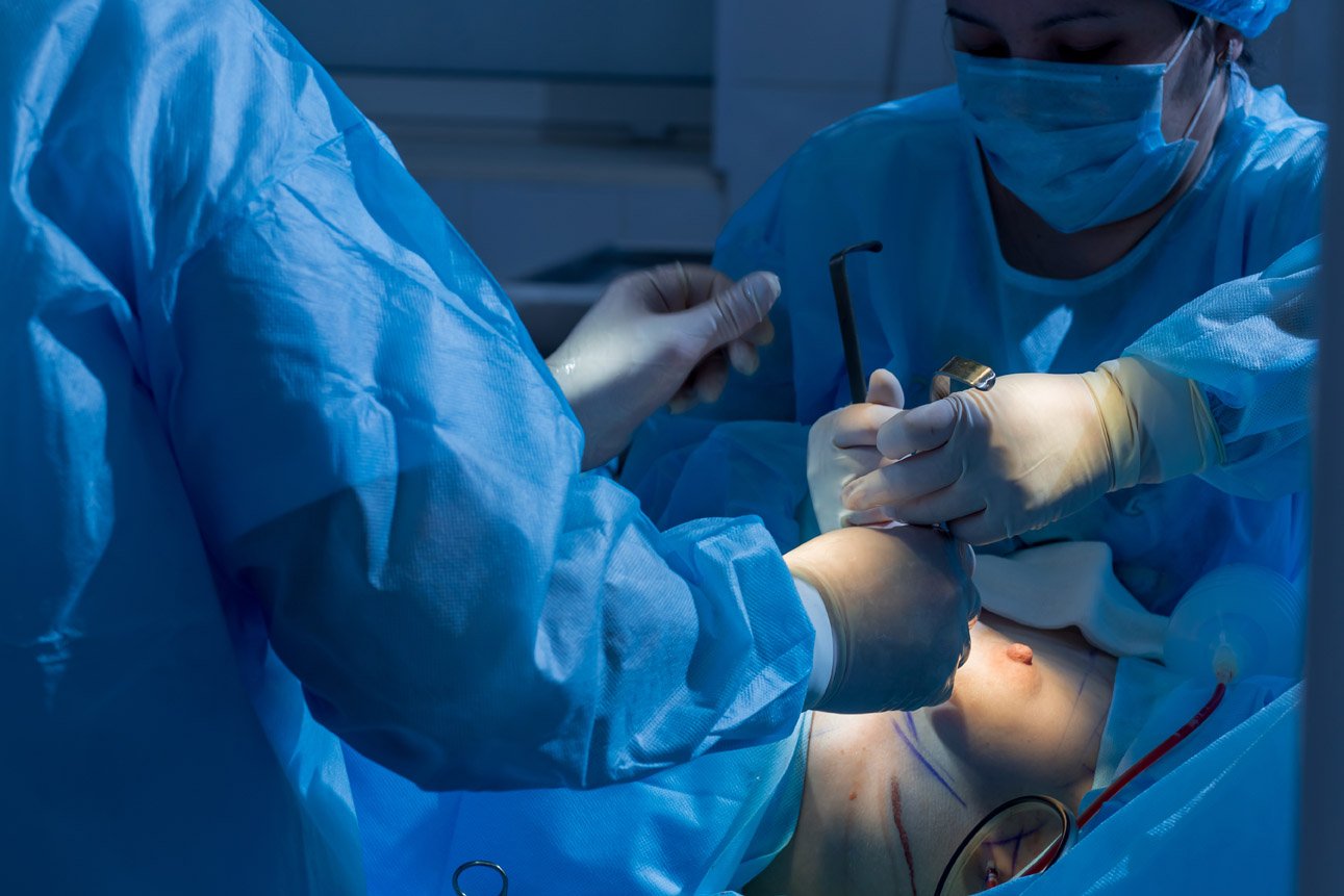 Surgeons team working with Monitoring of patient in surgical operating room. close-up breast augmentation