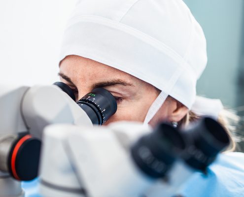 Doctor using microscope during eye surgery process, treatment of