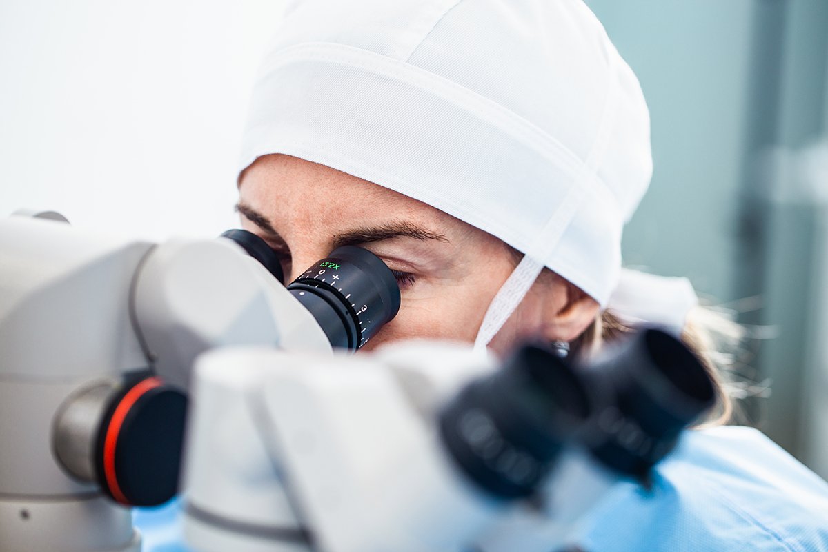 Doctor using microscope during eye surgery process, treatment of
