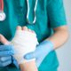 close up of doctor bandaging one hand after an accident